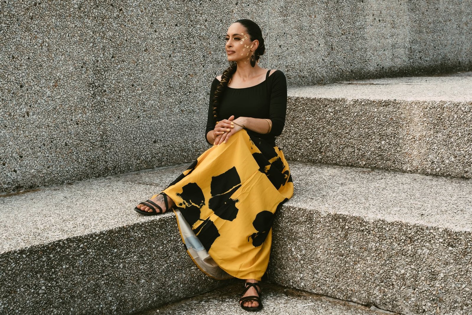 Tiffany P. seated in a concrete architectural setting